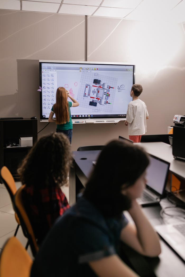 menu-13 Kids learning with an interactive board in a modern classroom setting.