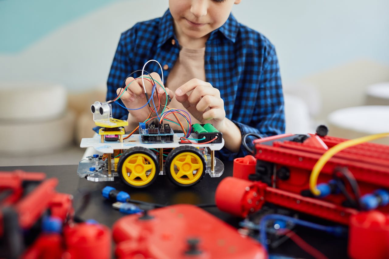 menu-16 Young boy engaged in assembling a robotic toy car, showcasing early interest in STEM education.