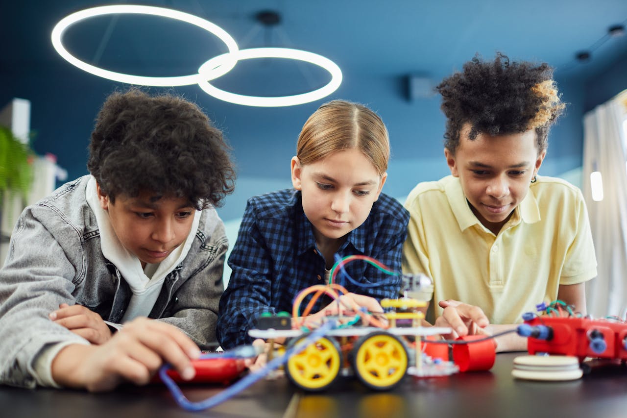 menu-03 Young students focus on building a robotics project together, showcasing teamwork and creativity.