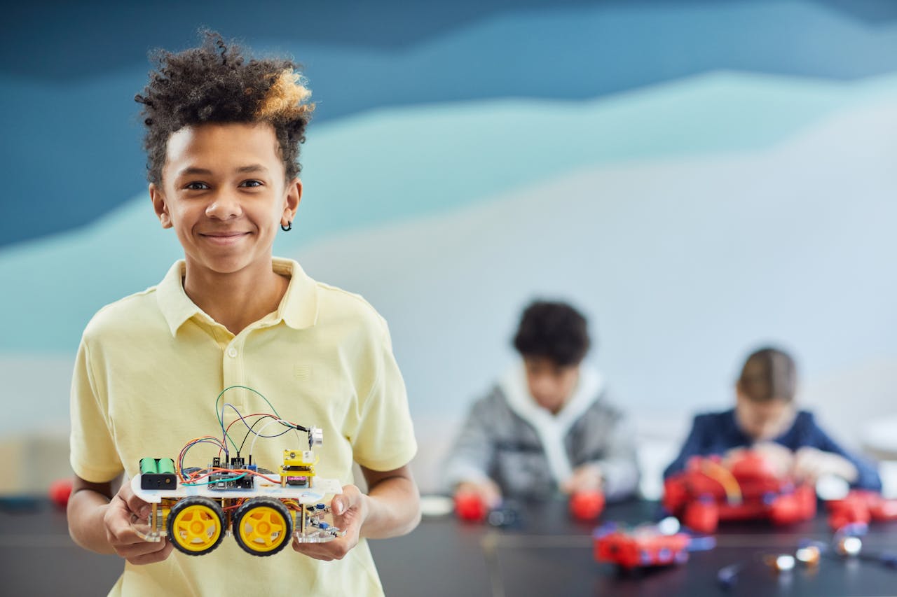 menu-01 Smiling student holds robotics project during a hands-on STEM activity in the classroom.