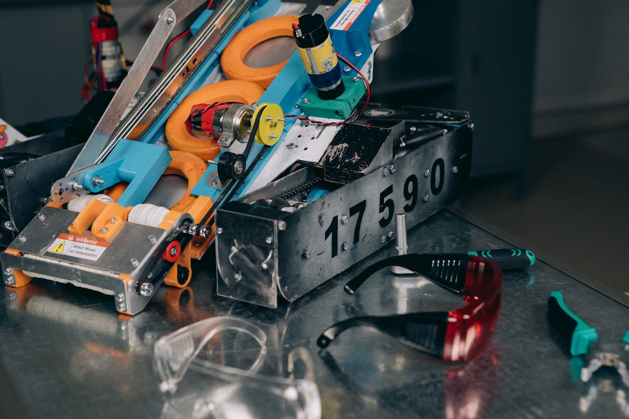 menu-09 Detailed shot of a robotics machine with safety glasses and tools on metal surface.
